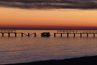 Sunset behind dilapidated fishing pier damaged by hurricanes on the Mississippi Gulf Coast in Long