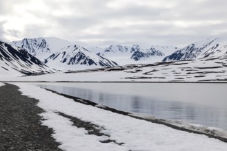 Pebble beach in a bay, mountain range, snow, Mushamna, Spitsbergen, Svalbard