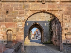 Alley with cobblestones leads through the town gate Oberes Tor, view through the gate to the