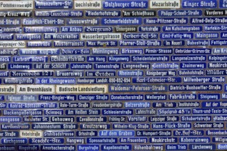 Wall with many blue street signs showing different names, Amorbach, Odenwald, Bavaria, Germany