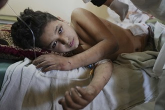 Wounded individuals receiving treatment at a hospital after being evacuated with difficulty from