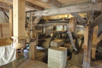 Interior view of mill, wooden construction, wooden beams, wheels, belt, drive wheel, flywheel,