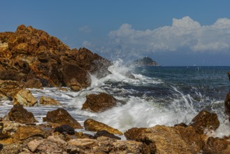Rugged rocks and foaming spray on Topinetti beach, near Rio Marina, Elba Island, Tuscan Archipelago