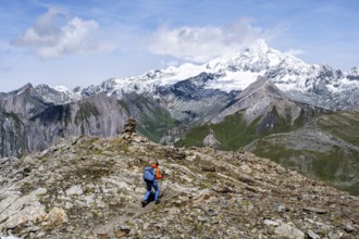 Mountaineer on a hiking trail, snow-covered and glaciated summit of the Großglockner in the