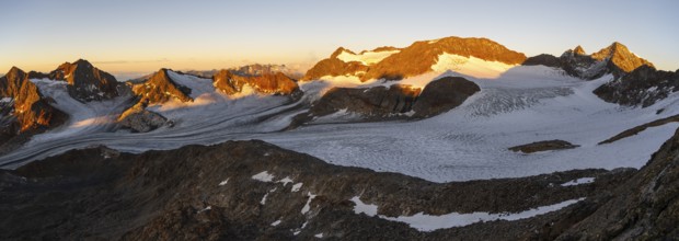 Picturesque high mountain landscape at sunrise with alpenglow, blue glacial lakes, glaciers and