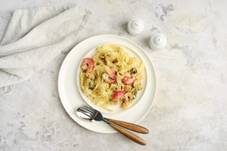 Fettuccine allo Scoglio, a delicious seafood pasta dish, is presented on a white plate with shrimp