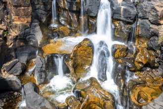 Waterfall on orange-coloured rock cliffs, long exposure, Blyde River, Bourke's Luck Potholes,