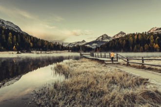 Young woman at Lake Staz near Sankt Moritz in the Engadine in Switzerland. Morning atmosphere with
