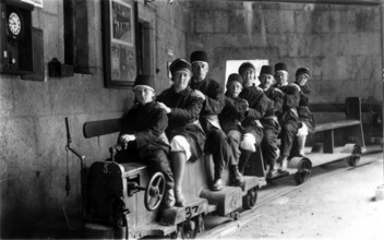 Family on a small railway, 1920s, A family sits together on a small mine train in tunnels,