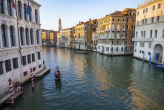 View of the Grand Canal with gondoliers at sunset, picturesque evening mood with palazzos on the