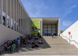 Tourists sitting on the stairs to the James Simon Gallery, Berlin, Germany