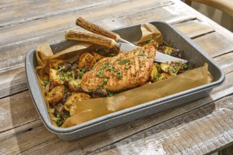 Roasted turkey breast is plated alongside an assortment of golden-brown vegetables, all garnished