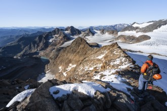 Mountaineer on a rocky ridge on the Wilder Freiger summit, behind him Signal summit and Becher