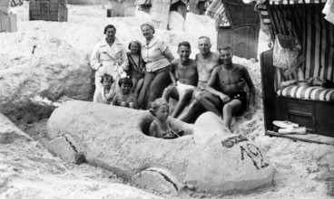 Sand car beach chair family, 1930s, family on the beach posing around a large sand car, relaxed and