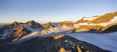 Picturesque high mountain landscape at sunrise with alpenglow, glacier and rocky mountain peaks in