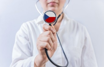 Female doctor holding stethoscope with Czech Republic flag. National health system of Czech