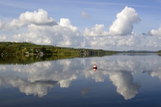 View over the Möhnesee, Möhnesee tower, red and white buoy, blue cloudy sky, reflection on the