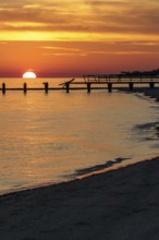 Sunset behind dilapidated fishing pier damaged by hurricanes on the Mississippi Gulf Coast in Long