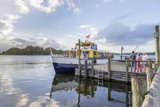 Water taxi boat with passengers approaching the dock of Fort Wilderness campground at Walt Disney