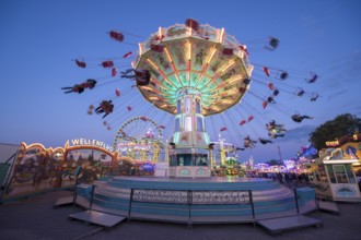 Lively carousel illuminated at a night fair, chain carousel, spring festival, Cannstatter