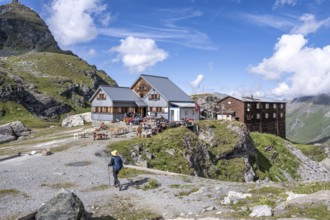 Mountaineer in front of mountain hut Cabane de Prafleuri in mountain landscape, Valais, Western