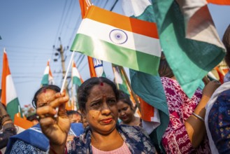 People holding Indian national flags as they take part in a rally, in soliderity with the Indian
