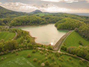 Spring landscape with a lake surrounded by forest between hills, Glems reservoir, Swabian Alb,