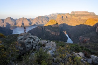 Hiker enjoying sunset at Blyde River Canyon with Three Rondawels peak, view of canyon with Blyde