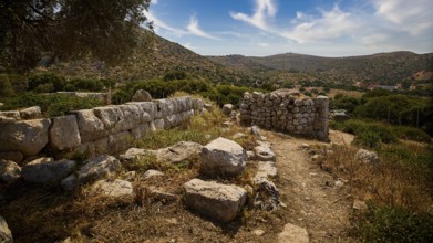 Heaven exchanged, ancient ruins in a hilly landscape with a clear blue sky and scattered clouds.