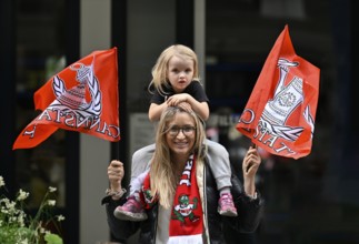 Woman, blonde, with girl, blonde, 4 years, sitting on shoulders, waving flags, flags of VfB