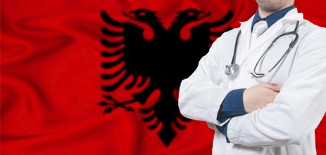 Albania healthcare concept. Male doctor on Albania flag. Doctor with crossed arms on Albania flag