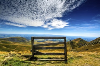 A wooden barrier stands at the edge of Sancy Mountain, providing a breathtaking view of the