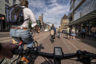 Ride your bike on the central cycle path on Lange Viestraat, Vredenburg, in the city centre of