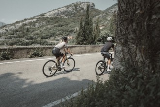 Woman and man cycling on Lake Garda in Italy. Sunny weather and dolce vita