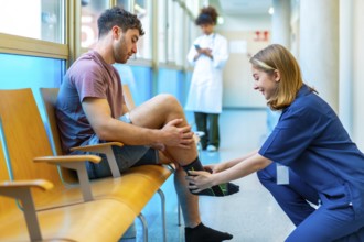 Young man sitting in a hospital waiting area receives assistance from a nurse who is putting a