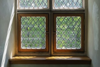 Old-fashioned windows with lattice pattern in the sunlight, wooden frames and shadows in the