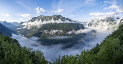 Panorama, view over the Geirangerfjord, atmospheric clouds over the fjord in the morning light,