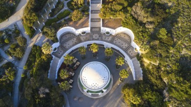 Drone shot, morning light, Symmetrical arrangement of buildings and gardens around a central dome,