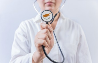 Female doctor holding stethoscope with Chipre flag. National health system of Chipre