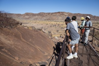 Tourists with guide at the rock engravings of Twyfelfontein, Twyfelfontein, Kunene, Namibia