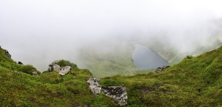 Wisps of mist drift over Kaltenbachsee, Schladminger Tauern, Sölktäler nature park Park, St.