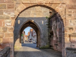 Alley with cobblestones leads through the town gate Oberes Tor, view through the gate to the