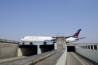 Aeroplane taxiing over a bridge over a road and cycle path, Amsterdam-Schiphol Airport, North