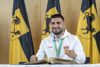 Deniz Undav signing the Golden Book of the City of Stuttgart. Reception organised by the state