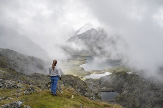 Mountaineer in front of mountain lakes Wangenitzsee and Kreuzsee, cloudy mountain peaks in the