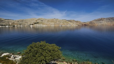 Clear bay surrounded by rocky hills under a blue sky, Bay of Emporio, Emporio, Symi, Dodecanese,