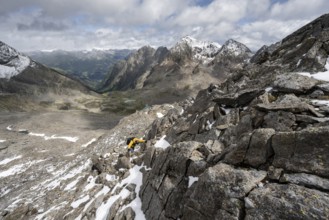 Mountaineer in rocky mountain landscape, descent from the summit of Keeskopf, behind summit of