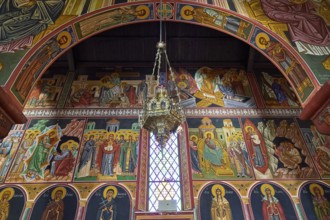 Artfully designed church interior with icons and large murals around a window, Church of the