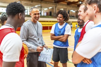 Basketball coach holding clipboard and explaining game strategy to his team players in a gymnasium