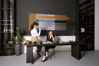Two professionals working together in a modern office with stylish decor during the day